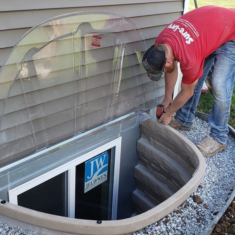 Person installing a DuraWell Egress Window Well Cover